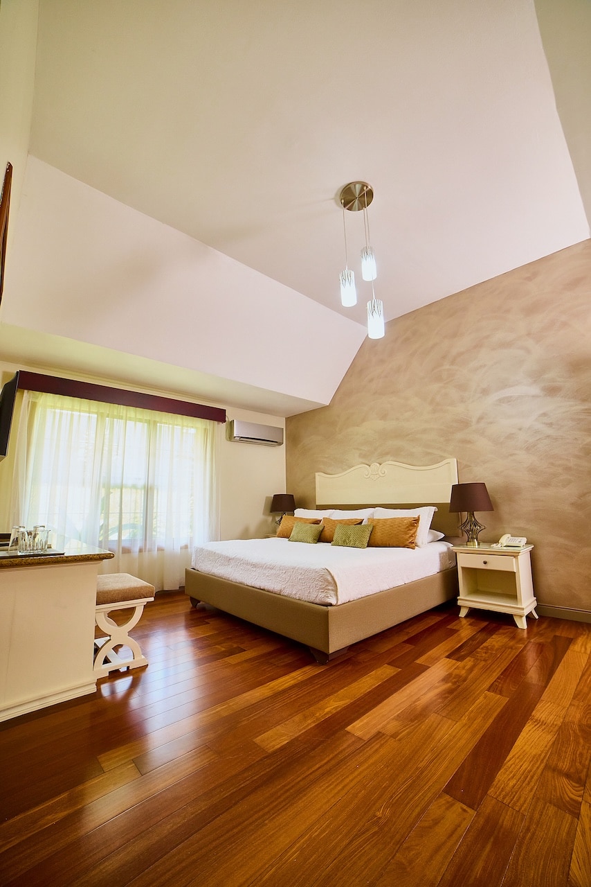 Chambre avec lit king size et parquet en bois à l'hôtel El Rodeo Estancia, au Costa Rica