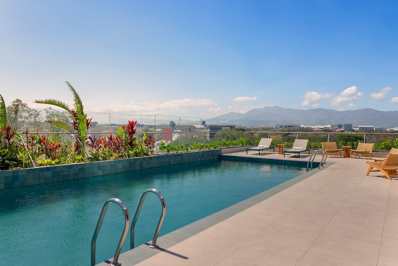 Transats et terrasse de la piscine chauffée du Hilton Garden Inn San Jose Airport City Mall, Costa Rica