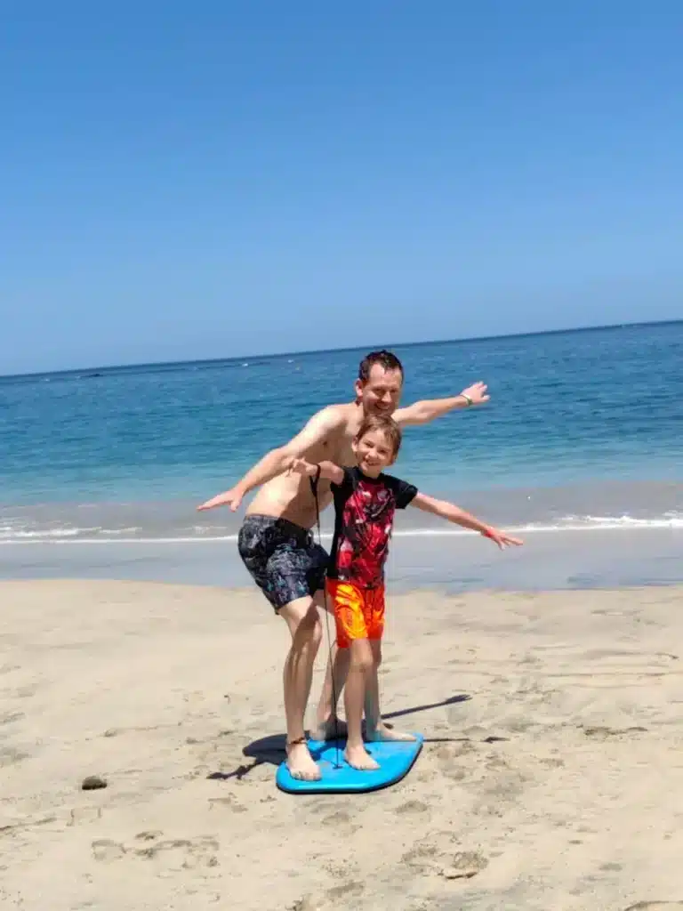 Vincent Varenne et son fils sur un bodyboard à la plage